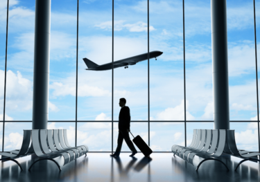 business man at the airport with an airplane in the background